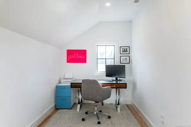 a view of a workspace with furniture and a window