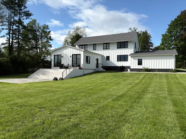 a front view of a house with a yard and trees