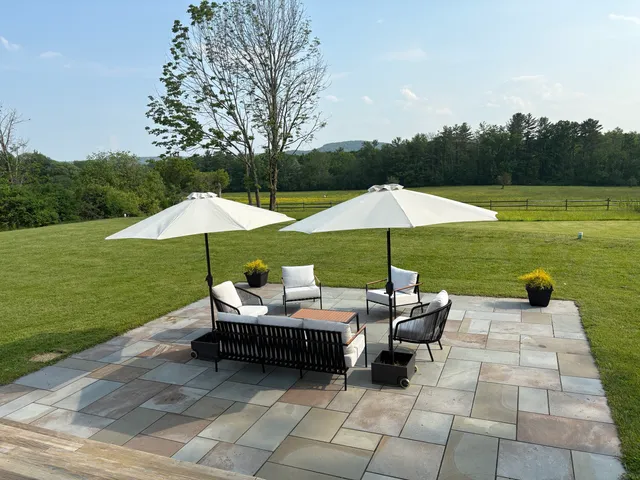 a view of a patio with a table and chairs under an umbrella
