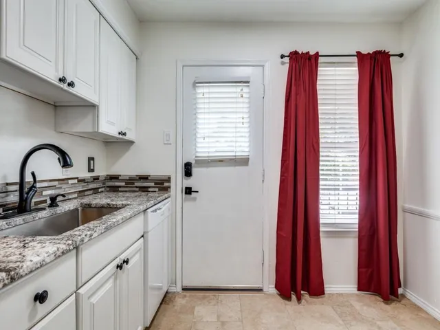 a kitchen with stainless steel appliances granite countertop a sink a stove and a wooden floor