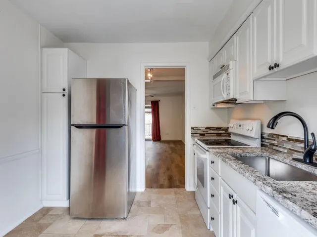 a kitchen with stainless steel appliances granite countertop a refrigerator and a sink
