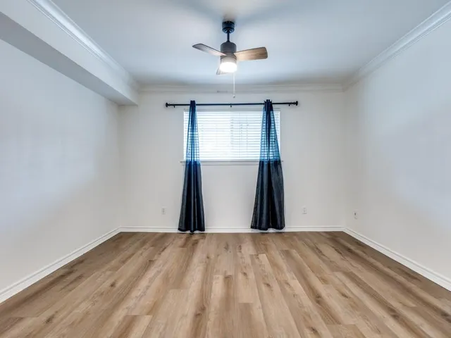 a view of a room with wooden floor and a ceiling fan