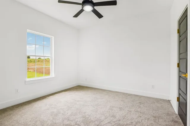an empty room with closet and windows