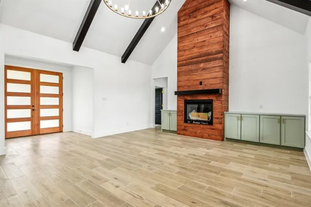 a view of empty room with wooden floor and fireplace