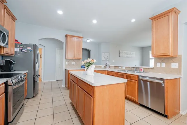 a kitchen with stainless steel appliances granite countertop a sink stove and cabinets