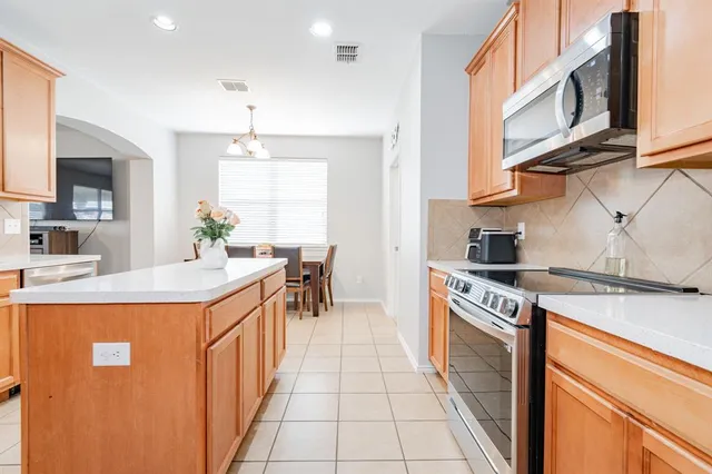 a kitchen with stainless steel appliances granite countertop a sink and a stove