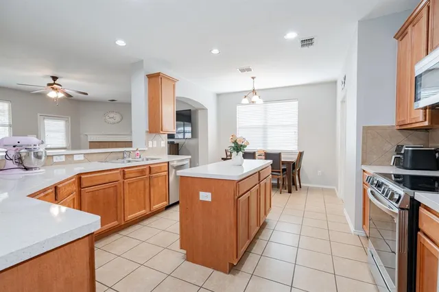 a kitchen with stainless steel appliances granite countertop a stove top oven a sink a counter top space and cabinets
