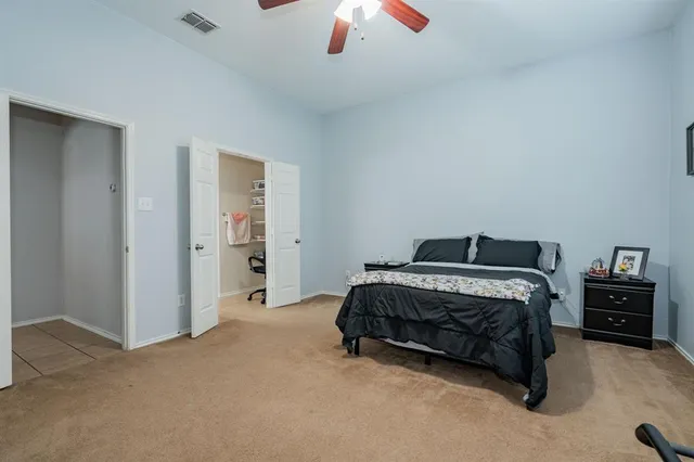 a spacious bedroom with a bed and a chandelier
