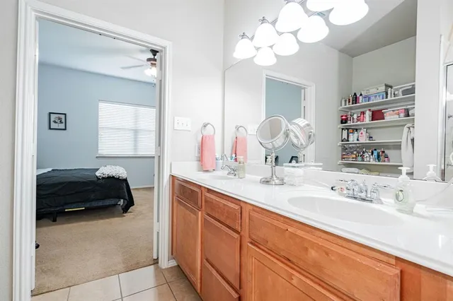 a en suite bathroom with a double vanity sink and a mirror