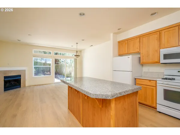 a kitchen with stainless steel appliances granite countertop a sink a stove and a refrigerator