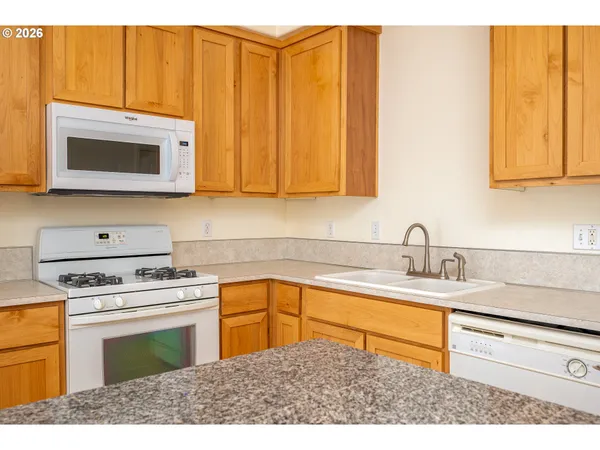 a kitchen with stainless steel appliances granite countertop a sink stove and microwave
