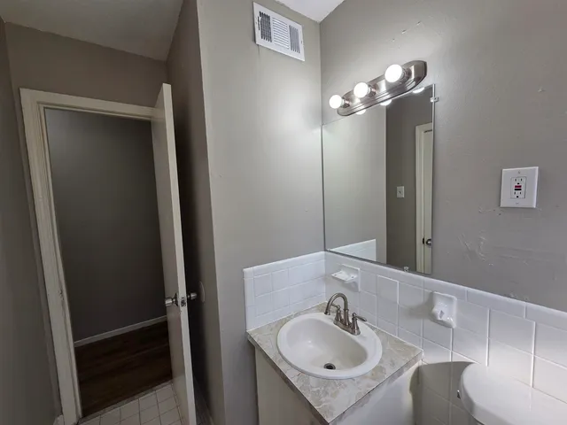 a bathroom with a bathtub shower sink vanity and a toilet