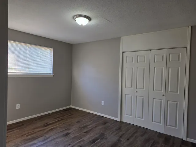 a view of an empty room with wooden floor