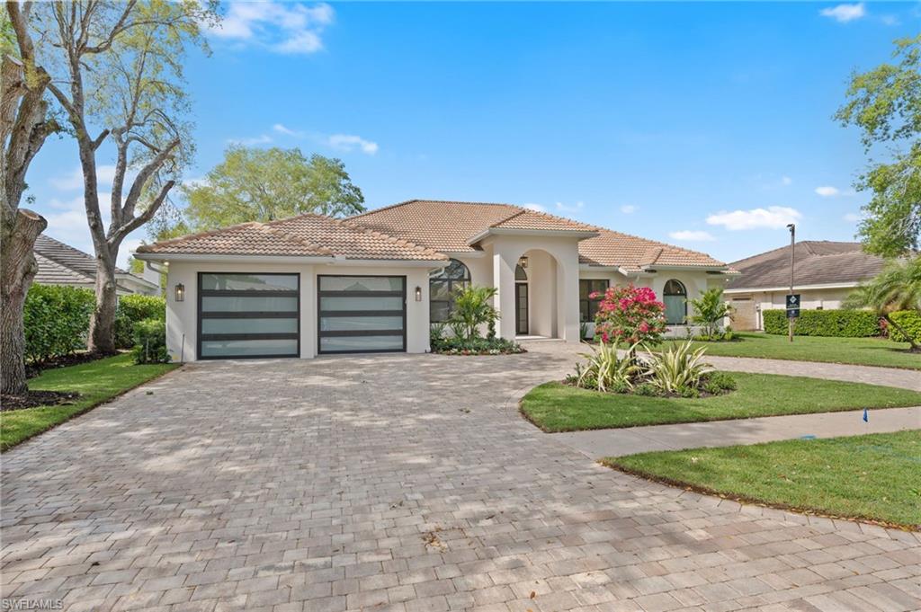 207 Monterey Drive Naples, FL 34119 - Photo 1 of 47 a front view of a house with a yard and garage