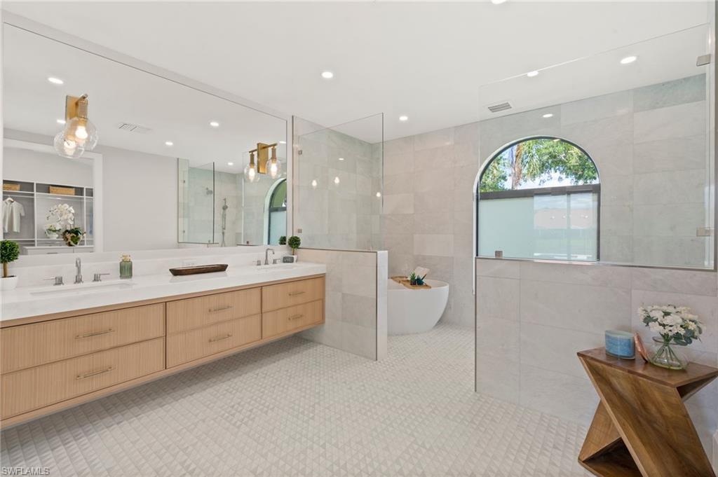 207 Monterey Drive Naples, FL 34119 - Photo 20 of 47 a large bathroom with a window double vanity sink and a mirror