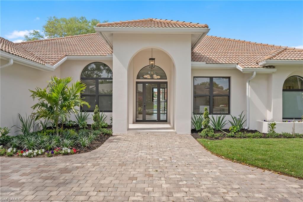 207 Monterey Drive Naples, FL 34119 - Photo 2 of 47 a front view of a house with garden
