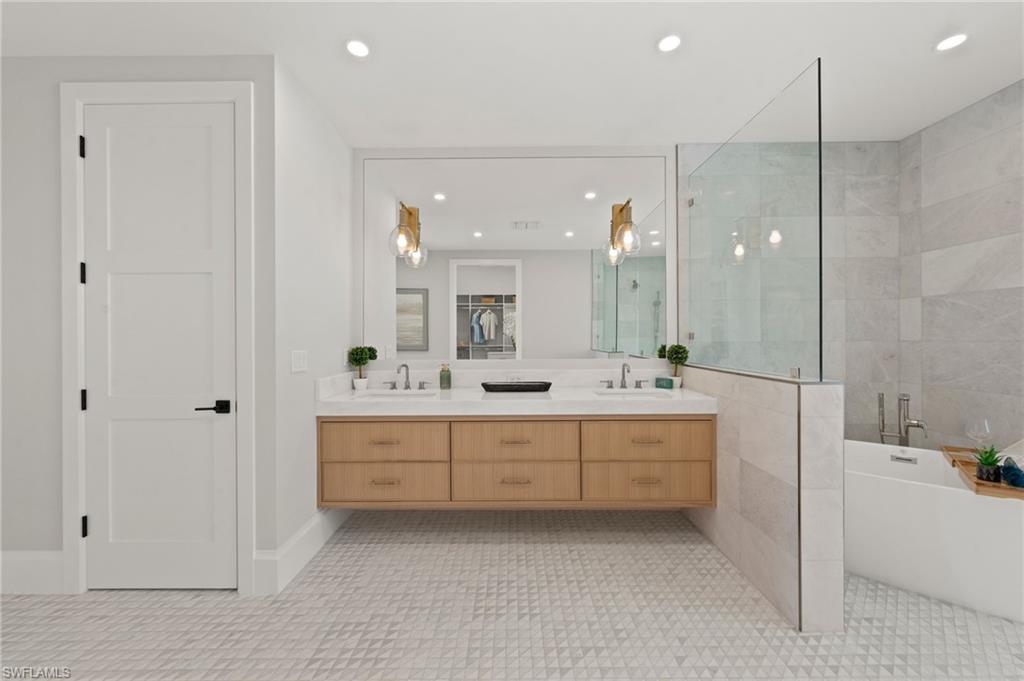 207 Monterey Drive Naples, FL 34119 - Photo 21 of 47 a bathroom with a bathtub sink and mirror