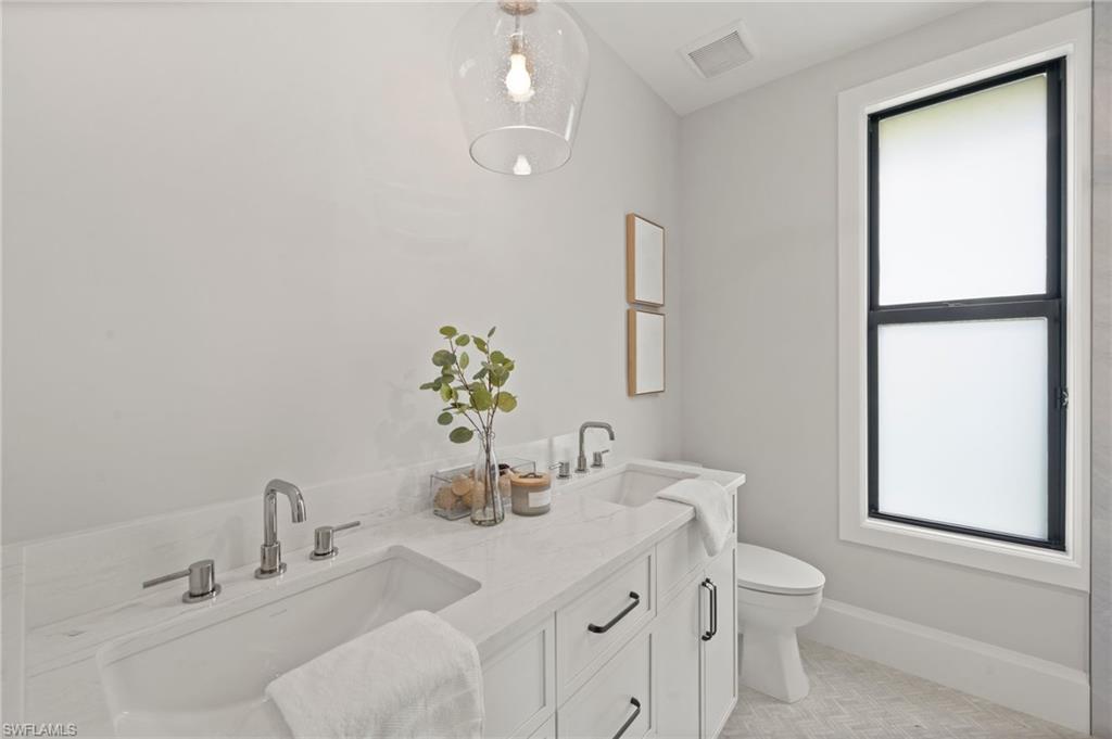 207 Monterey Drive Naples, FL 34119 - Photo 26 of 47 a bathroom with a sink toilet and vanity