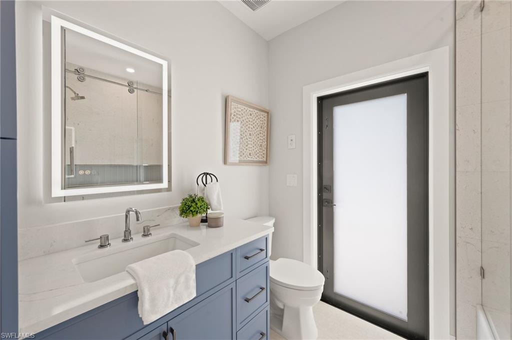 207 Monterey Drive Naples, FL 34119 - Photo 30 of 47 a bathroom with a sink toilet a tub and a mirror