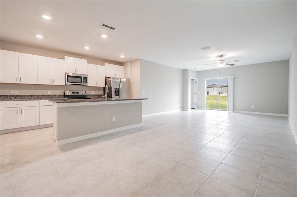 31807 Barrel Wave Way Wesley Chapel, FL 33545 - Photo 13 of 61 a kitchen with stainless steel appliances granite countertop a stove top oven a sink a refrigerator and a granite counter tops