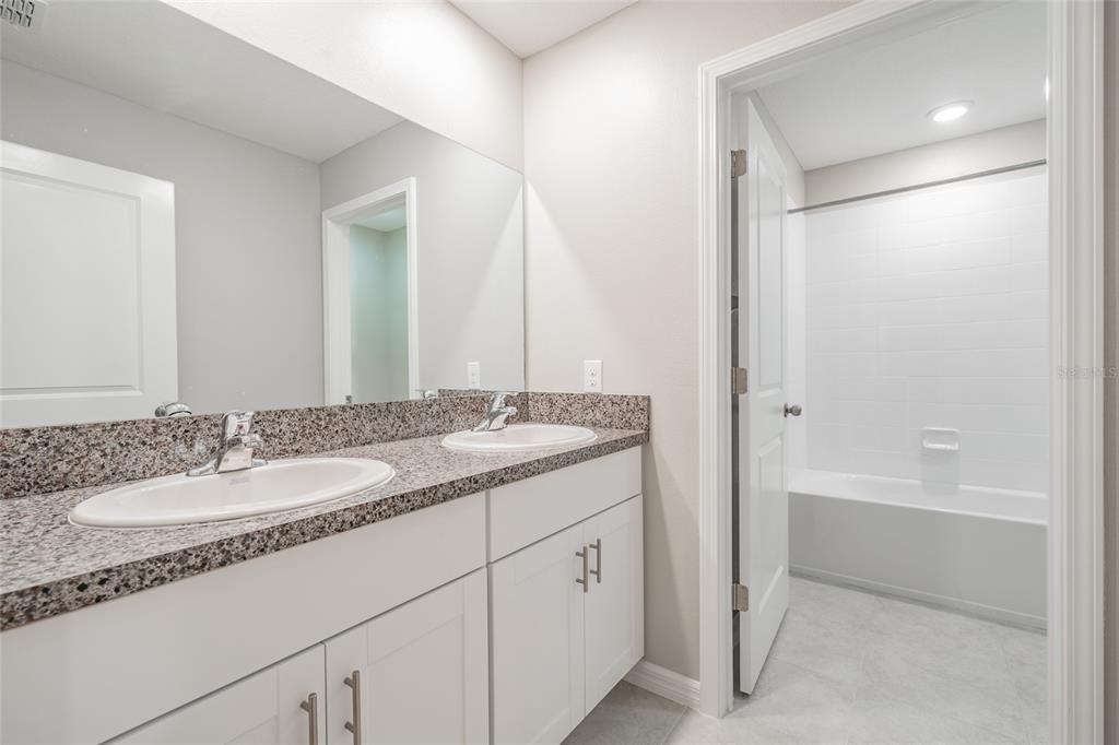 31807 Barrel Wave Way Wesley Chapel, FL 33545 - Photo 18 of 61 a bathroom with a granite countertop sink and a mirror