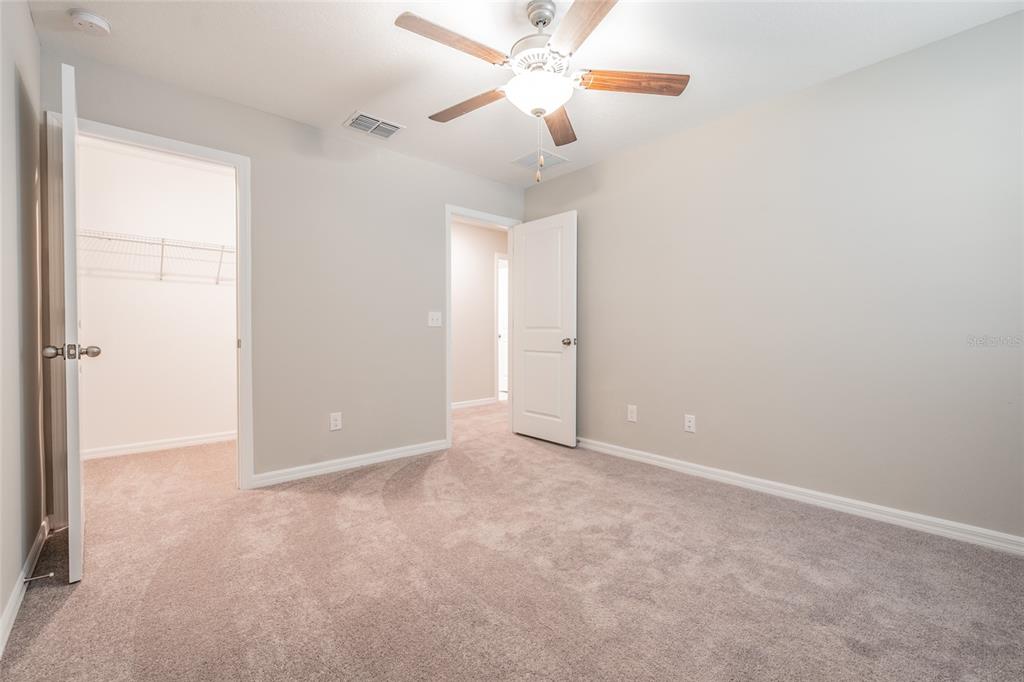 31807 Barrel Wave Way Wesley Chapel, FL 33545 - Photo 23 of 61 an empty room with closet and a chandelier fan