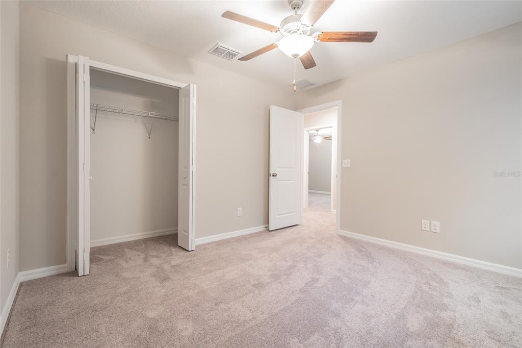31807 Barrel Wave Way Wesley Chapel, FL 33545 - Photo 25 of 61 an empty room with a fan & a fan