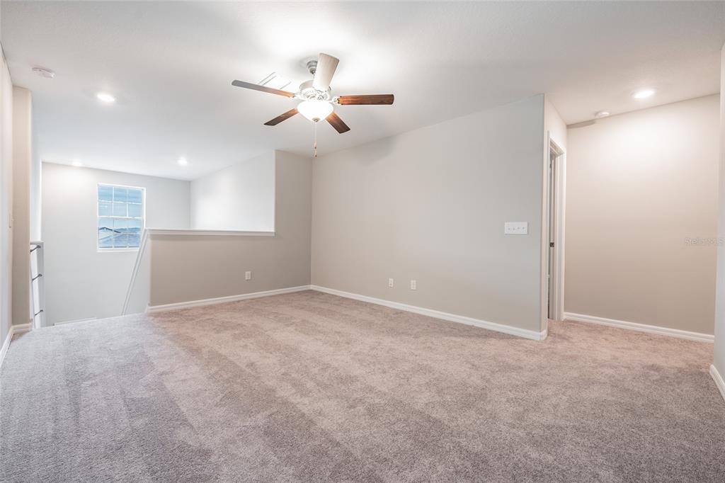 31807 Barrel Wave Way Wesley Chapel, FL 33545 - Photo 26 of 61 a view of an empty room with a chandelier fan