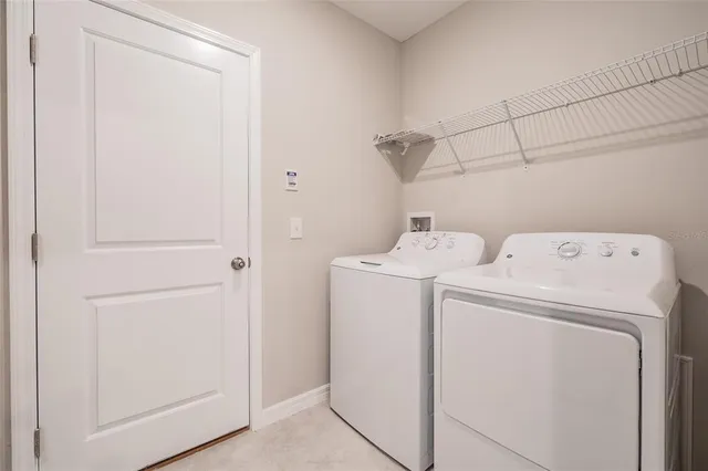 a kitchen with kitchen island granite countertop a sink a stove a microwave a refrigerator and white cabinets