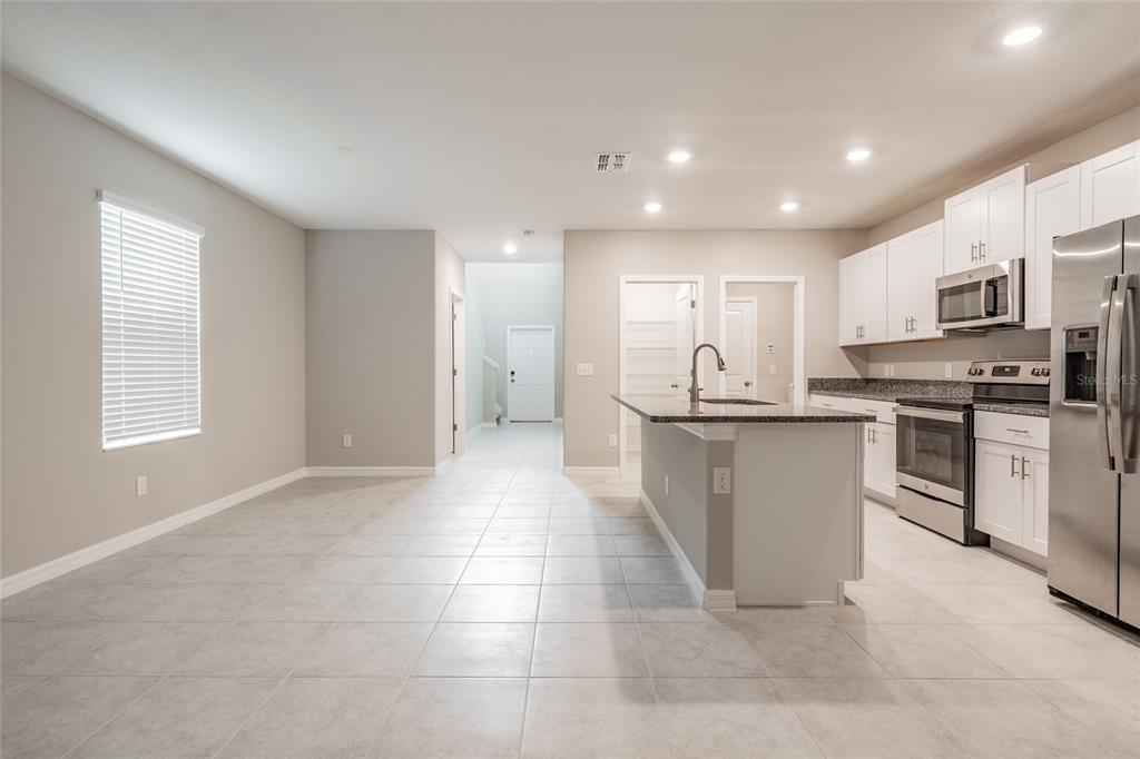 31807 Barrel Wave Way Wesley Chapel, FL 33545 - Photo 38 of 61 a kitchen with stainless steel appliances granite countertop a stove top oven a sink and dishwasher