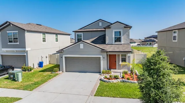 a front view of a house with a yard and trees