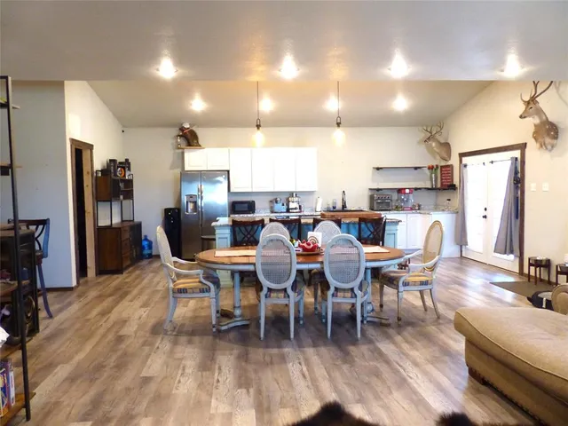 a large kitchen with lots of furniture a sink appliances and wooden floor