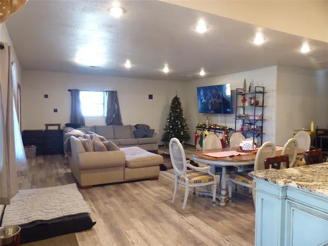a living room with furniture a wooden floor and kitchen view