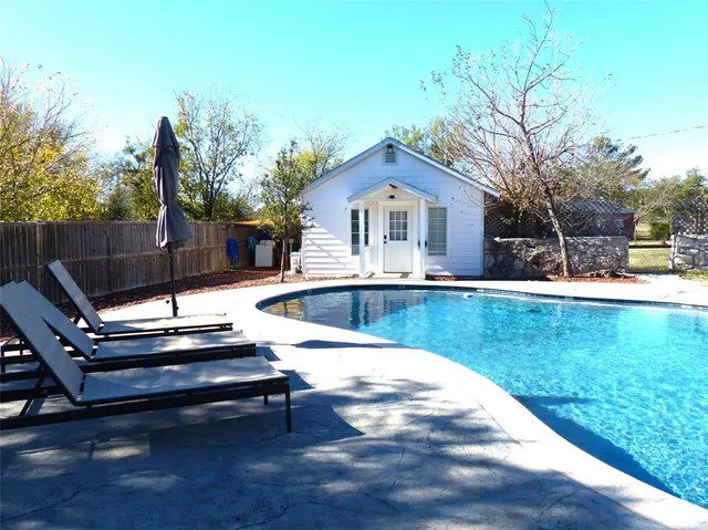 a view of a house with swimming pool and sitting area