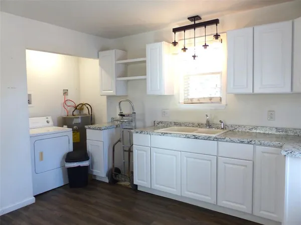 a kitchen with a sink cabinets and wooden floor