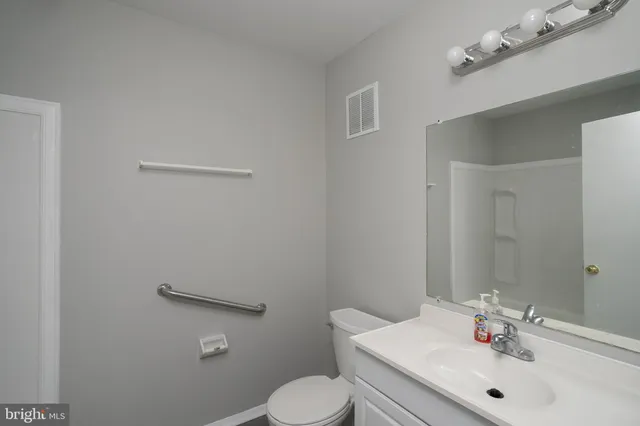 a bathroom with a sink mirror and toilet