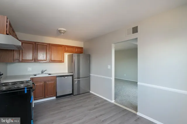 a kitchen with stainless steel appliances granite countertop a refrigerator and a sink