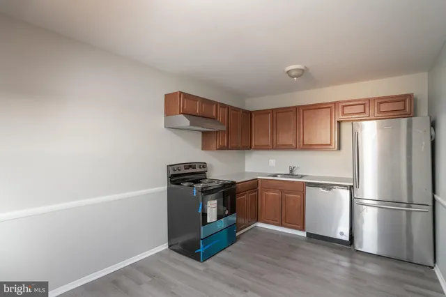 a kitchen with stainless steel appliances a stove a refrigerator and wooden cabinets