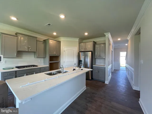 a kitchen with stainless steel appliances a refrigerator sink and white cabinets