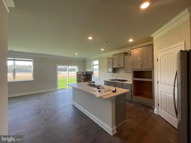 a kitchen with kitchen island a sink stove and refrigerator