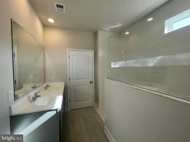 a bathroom with a sink a shower and a mirror