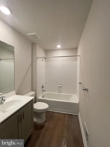 a bathroom with a bathtub shower sink vanity and toilet
