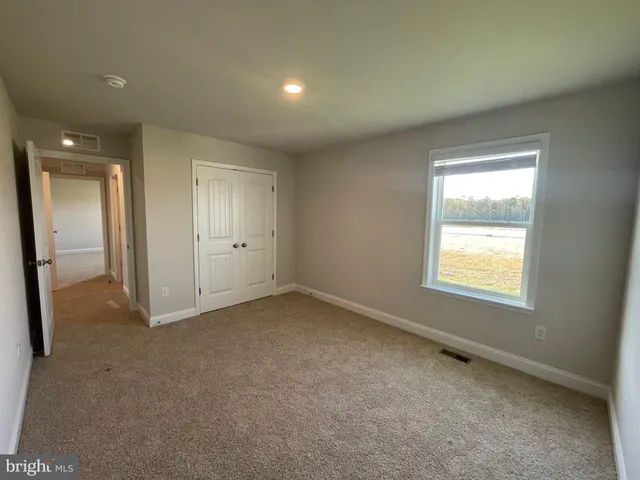 an empty room with a window and a kitchen