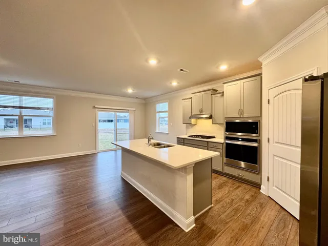 a view of kitchen with wooden floor and electronic appliances