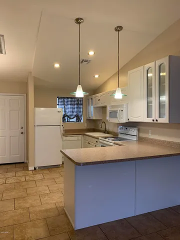 a kitchen with kitchen island granite countertop a sink a counter top space and cabinets
