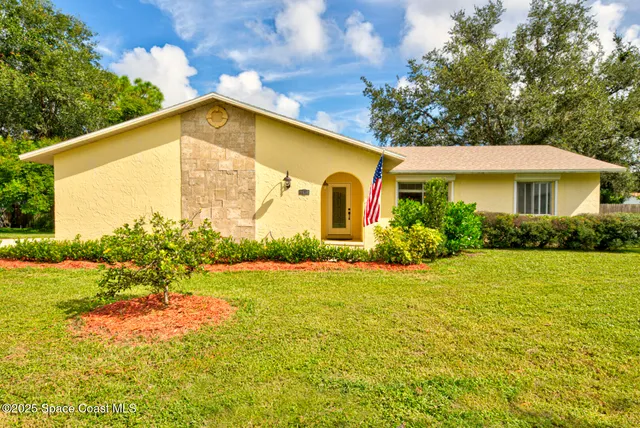 a view of a house with backyard and garden