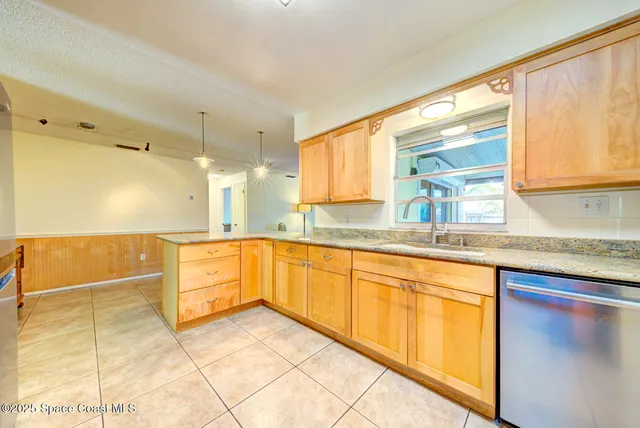 a large kitchen with granite countertop a sink and a window