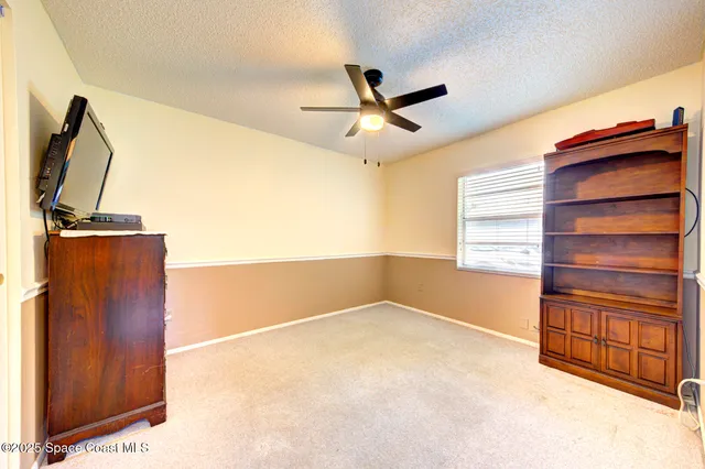 a bedroom with a bed and a ceiling fan
