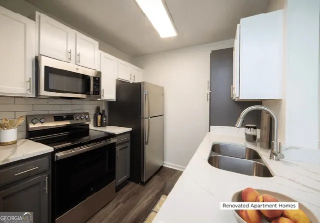 a kitchen with stainless steel appliances a stove a sink a refrigerator and cabinets