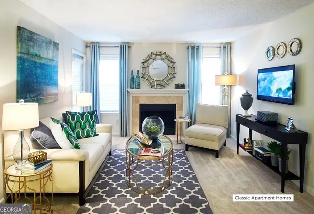 a living room with furniture a rug a fireplace and a window